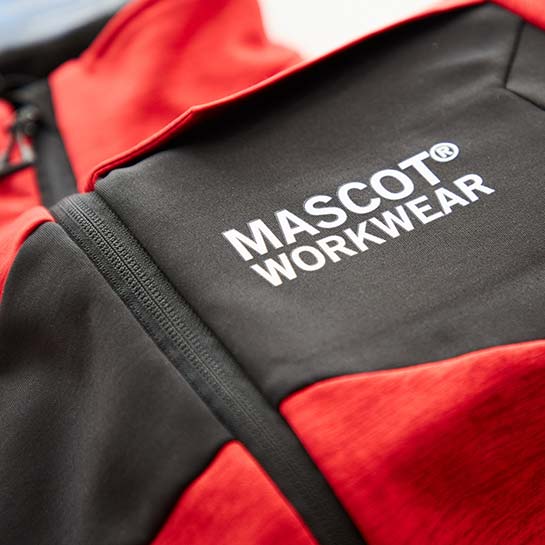 Detailaufnahme des Mascot-Logos auf einer roten Jacke.