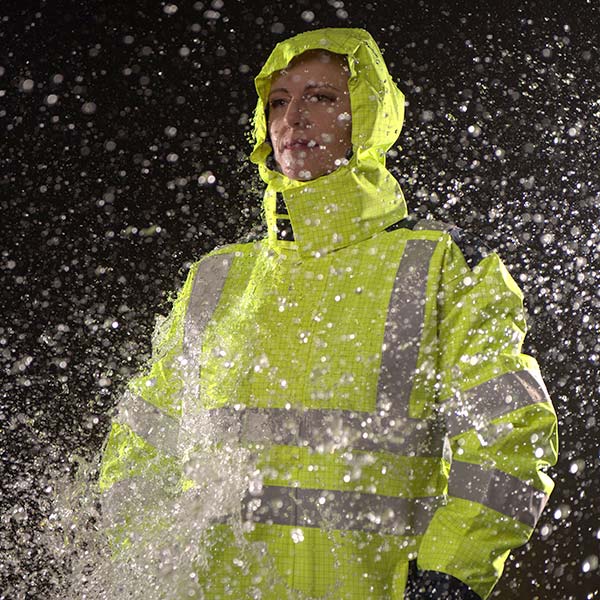 Blick auf eine Person, die Warnschutzkleidung trägt, welche auch regenfest ist.