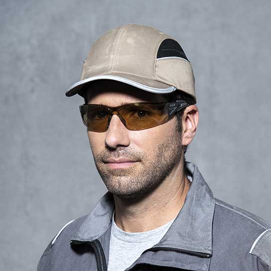 Blick auf eine getönte Augenschutzbrille, welche von einem Mann getragen wird.
